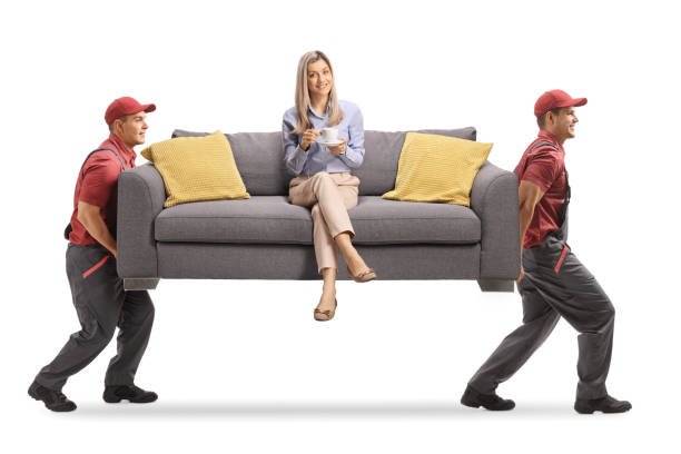 istock Two guys carrying a sofa with a woman sitting and drinking coffee 1263933309