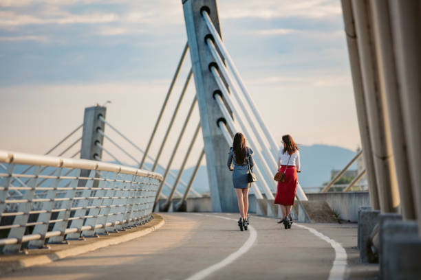 Two women on electric push scooters