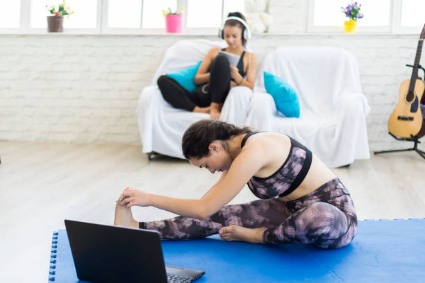 eine frau, die yoga im wohnzimmer macht. - the splits flexibility yoga teenage girls stock-fotos und bilder