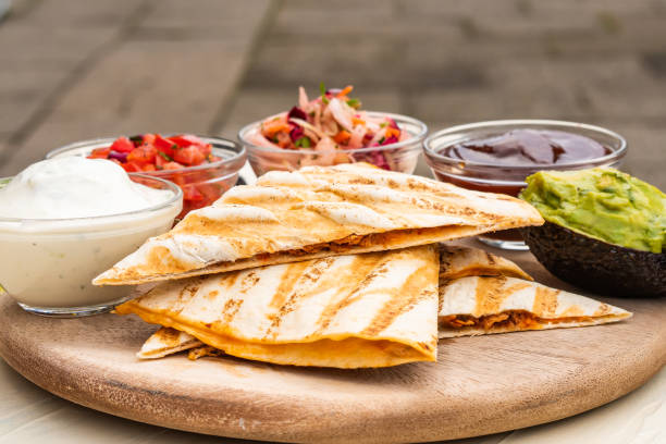 istock Mexican traditional authentic homemade quesadilla with pulled pork beef chili con carne serve with tomato salad and avocado guacamole and dip sauce 1263938743