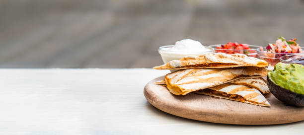 mexikanische traditionelle authentische hausgemachte quesadilla mit gezogenen schweinefleisch chili con carne servieren mit tomatensalat und avocado guacamole und dip-sauce - 2545 stock-fotos und bilder