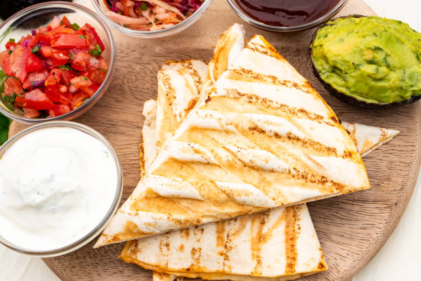 istock Mexican traditional authentic homemade quesadilla with pulled pork beef chili con carne serve with tomato salad and avocado guacamole and dip sauce 1263938776