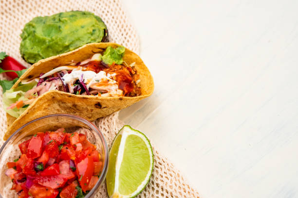 istock Mexican traditional authentic homemade tacos with pulled pork beef chili con carne serve with tomato salad and avocado guacamole and dip sauce 1263938859
