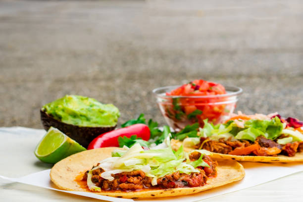 istock Mexican traditional authentic homemade tacos with pulled pork beef chili con carne serve with tomato salad and avocado guacamole and dip sauce 1263938870