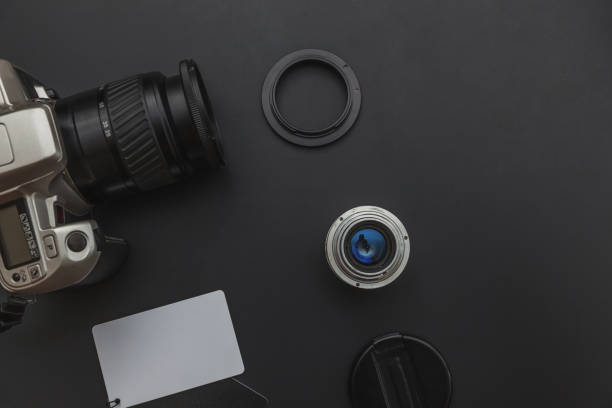 istock Photographer workplace with dslr camera system, camera cleaning kit, lens and camera accessory on dark black table background. Hobby travel photography concept Flat lay top view copy space 1263938904