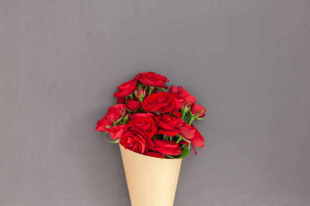 istock Red rose bouquet wrapped vintage craft paper. 1263938916