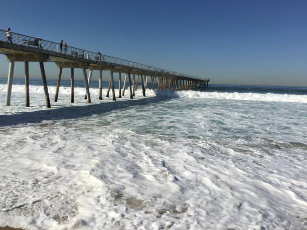 istock Enormous waves roll under the pier and cover the beach 1263938980