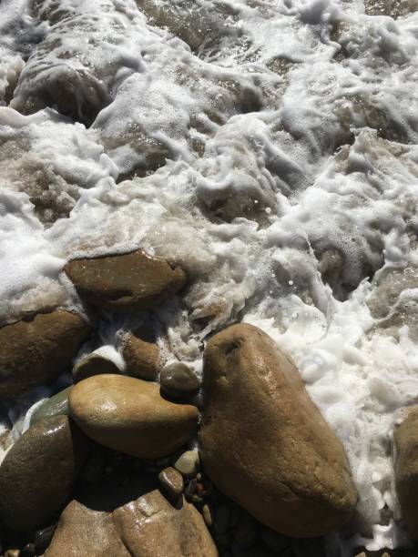 les vagues se précipitent sur les rochers - tide energy water textured photos et images de collection