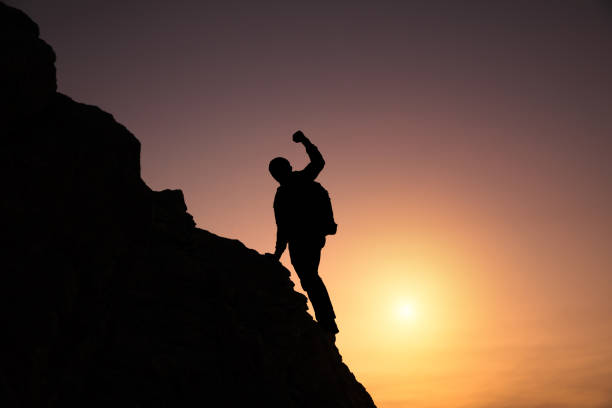man to climb in mountain at the sunset