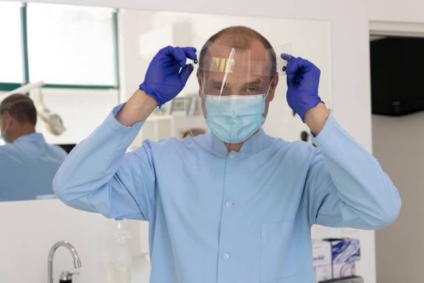 istock A dentist who prepares for an examination with a protective face mask. Work during a pandemic. 1263958265