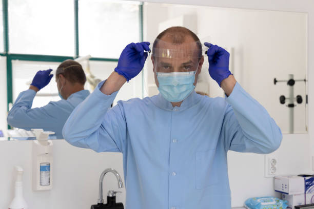 istock A dentist who prepares for an examination with a protective face mask. Work during a pandemic. 1263958270
