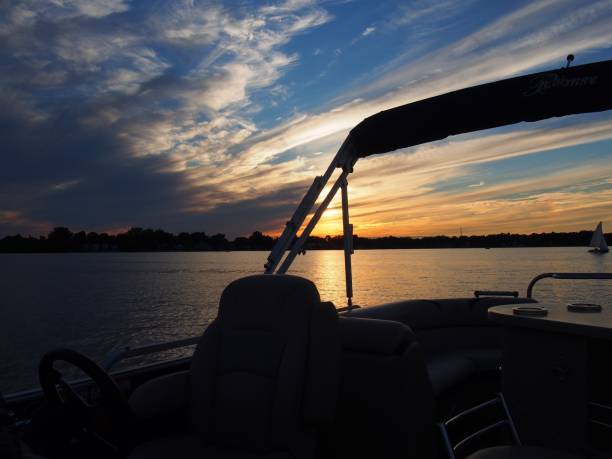 Lake Reflections - Boating Life Lake Sunset Reflecting on Pontoon Boat pontoon boat stock pictures, royalty-free photos & images
