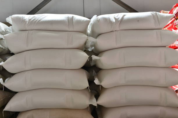 istock Many rows of plastic white sacks with goods are in big warehouse 1263962510
