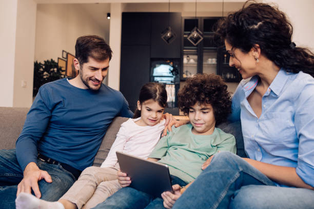 istock Happy family using digital tablet together 1263965501
