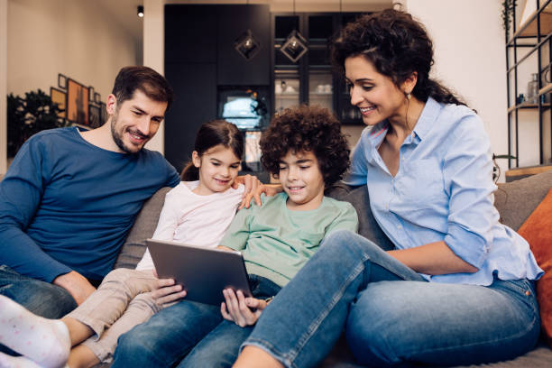 istock Happy family watching something together on digital tablet 1263965503