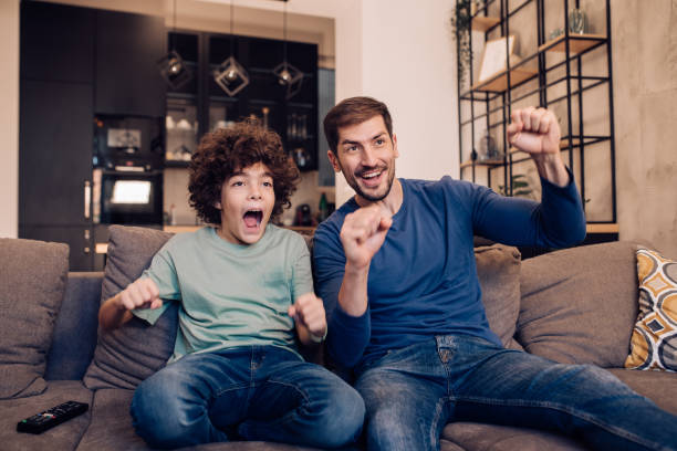 istock Boy and his father watching the game and cheering 1263965558
