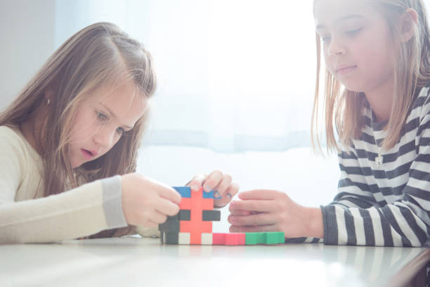 istock Schoolgirls on a Break Playing with Block Puzzle 1263966141