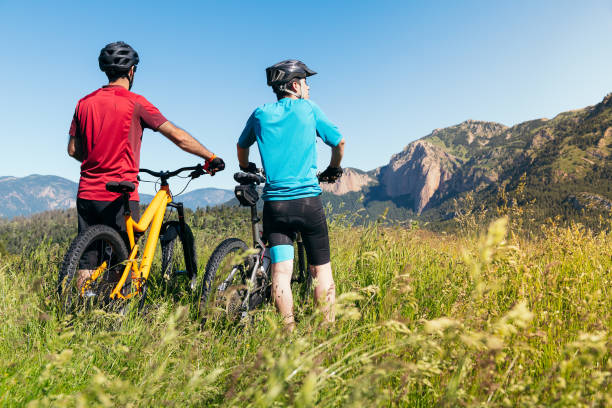 istock two men with their bikes looking the mountains 1263966244