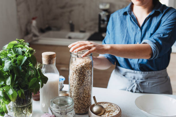 istock Making a Healthy and Nutritious Breakfast: Woman Pouring Rolled Oats into a Bowl 1263968049