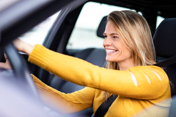 車を運転して幸せな若い女性。 - car insurance driving women ストックフォトと画像