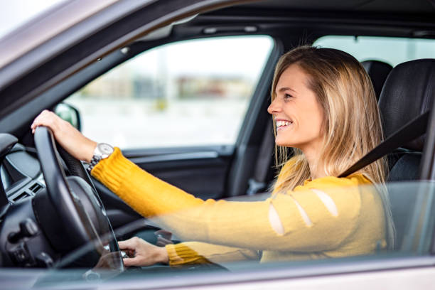 istock Happy young woman driving a car. 1263973850