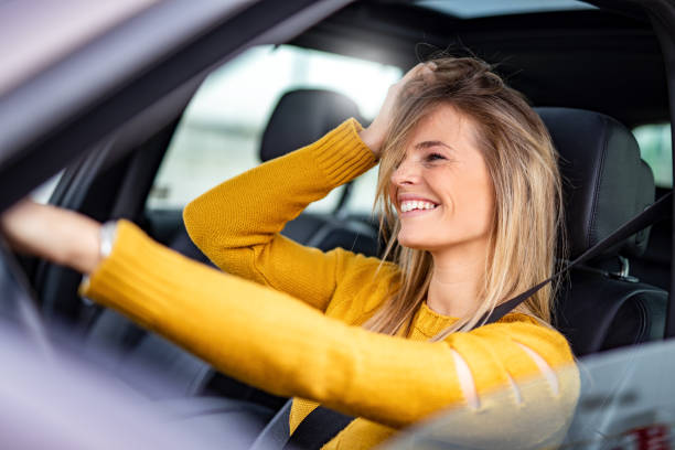 istock Happy young woman driving a car. 1263974382