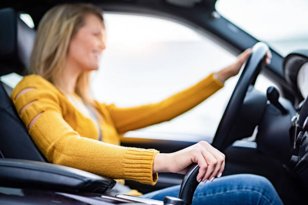 若い女性の手がギアをシフトし、車を運転しているのをクローズアップします。 - car insurance driving women ストックフォトと画像