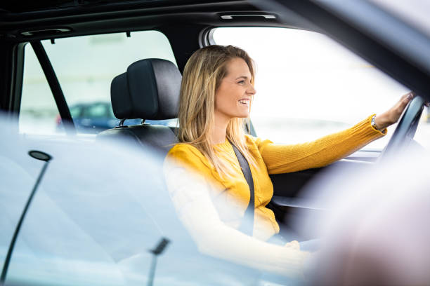 bella giovane donna alla guida di un'auto. - car insurance women driving foto e immagini stock