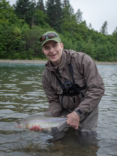 un pêcheur retenant un saumon rose pêché sur la rivière kitimat, canada - landscape canada north america freshwater fish photos et images de collection