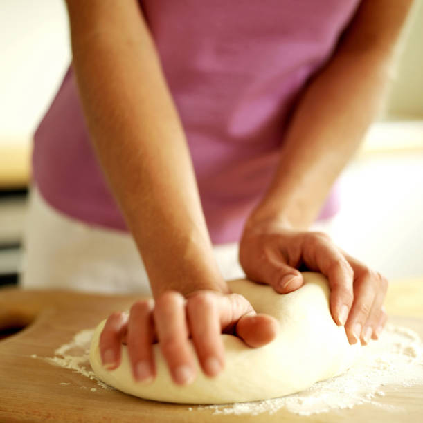 istock Woman kneading pizza dough 1263980822