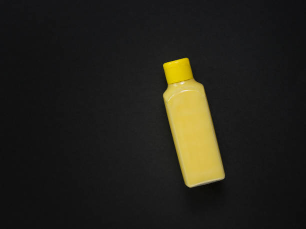 istock A yellow plastic bottle with a yellow liquid on a black background. 1263983010