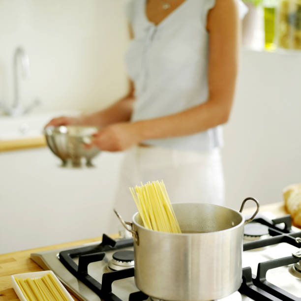 istock Woman cooking spaghetti at home 1263983692