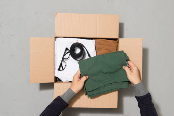 istock Man hands putting clothes to donate box 1263989312