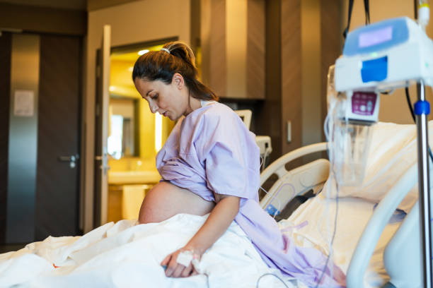 молодая беременная женщина в больничной палате и готова к роду ребенка. - delivery room стоковые фото и изображения