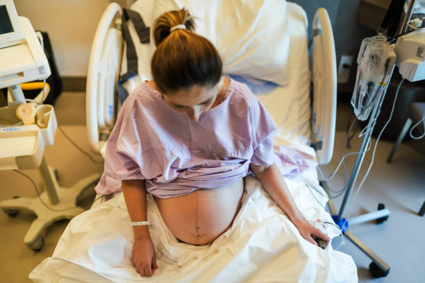 jovem grávida na ala hospitalar e pronta para dar à luz. - delivery room - fotografias e filmes do acervo