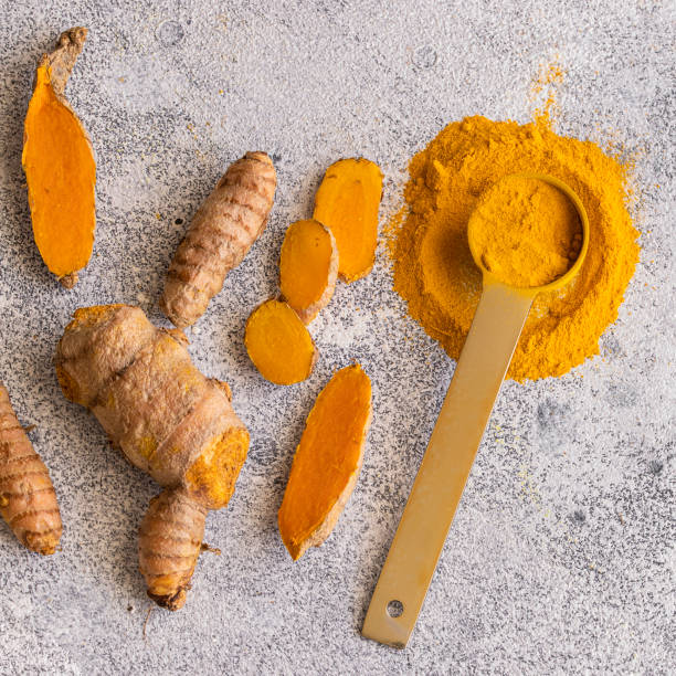 istock Turmeric  roots and turmeric powder on light concrete background with copy space. Tumeric used as spice for food and treatment in alternative medicine 1264008568