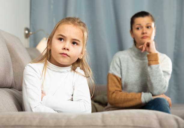 istock Frustrated small girl sitting at sofa,  having conflict with mother 1264009628