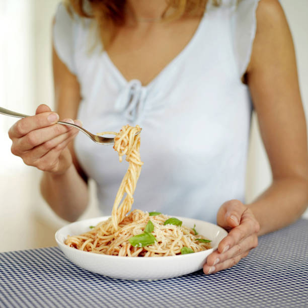 istock Woman eating pasta 1264010947