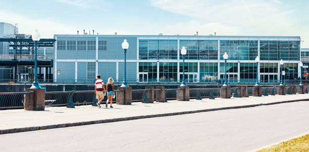 молодая канадская пара гуляет по улице в старой портовой гавани в монреале - montreal harbor old commercial dock стоковые фото и изображения