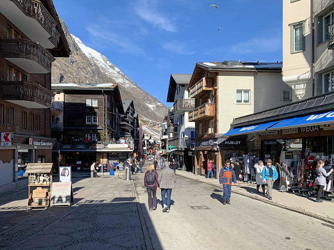 Zermatt, Switzerland - February 15, 2020: A main street crowded with tourists in the center of world famous Zermatt village, Mattertal, Valais canton, Switzerland in winter.