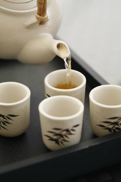 istock Pouring tea into teacups on tray 1264016646