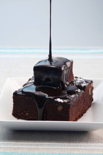 istock Pouring chocolate syrup onto brownies 1264016754