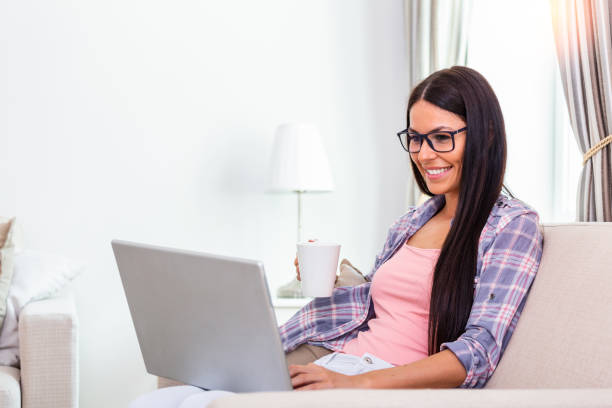 istock Beautiful woman freelancer noting information for planning project doing remote job via laptop computer. Girl laughing while reading email on modern laptop device . 1264019506