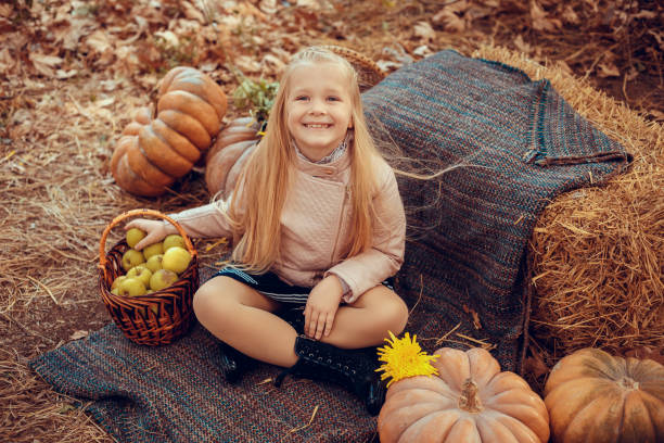 秋の自然の中でかわいいと面白いハリネズミの赤ちゃんと美しい小さな女の子 - single flower flower autumn pumpkin ストックフォトと画像
