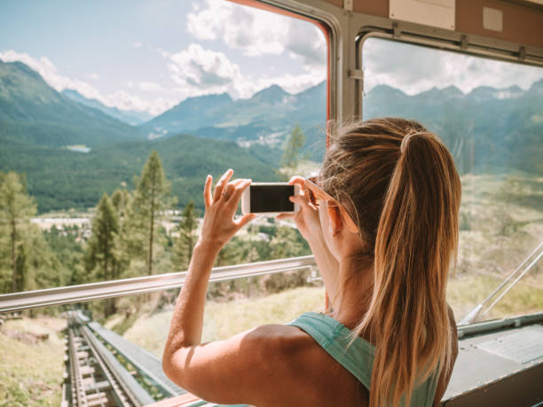 Tourist taking photo with phone of beautiful mountain landscape from cable car Tourist taking photo with phone of beautiful mountain landscape from cable car. People travel summer enjoying outdoor activities exploring nature overhead cable car photos stock pictures, royalty-free photos & images