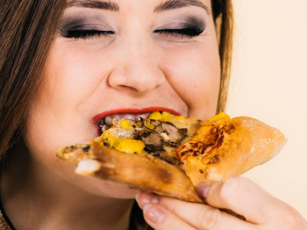 istock Woman eating hot pizza slice 1264032663
