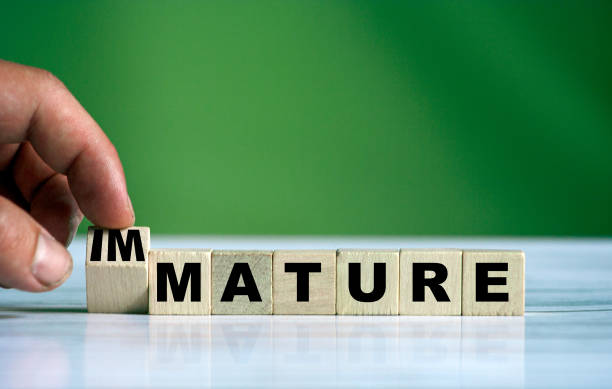 istock The hand turns the wooden cube and changes the MATURE to IMMATURE 1264037075
