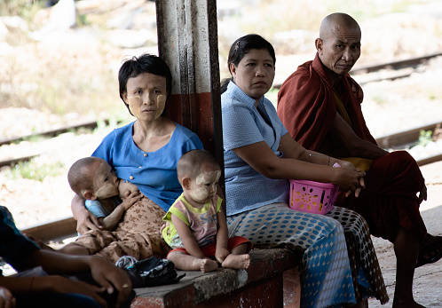 Yangon, Myanmar - February 22, 2014: Young Woman Breastfeeding Her Baby At The Train Station In Yangon
