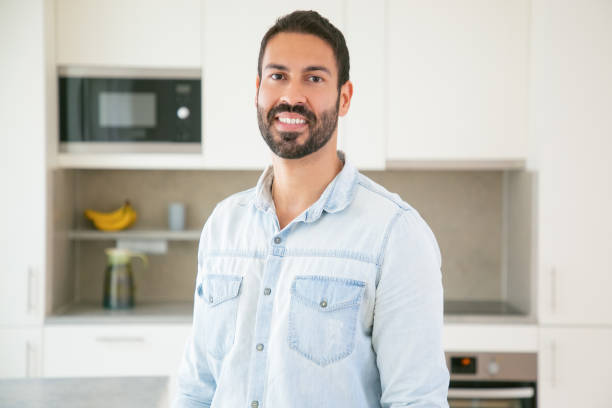 istock Cheerful attractive dark haired Latin man posing in kitchen 1264042149