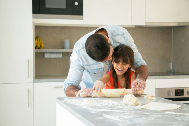 istock Joyful girl and her dad having fun in kitchen 1264042391